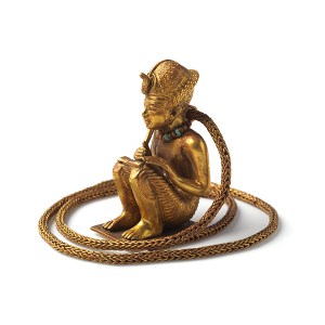 Figurine prosternée et chaine en or représentant un roi accroupi.